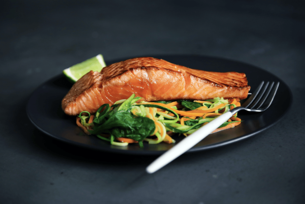 a photo of a cooked salmon dish with a vegetable medley. This fish is considered safe to eat when you are pregnant.